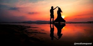 couple dancing at beach during sunset