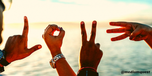 two persons forming love sign using fingers